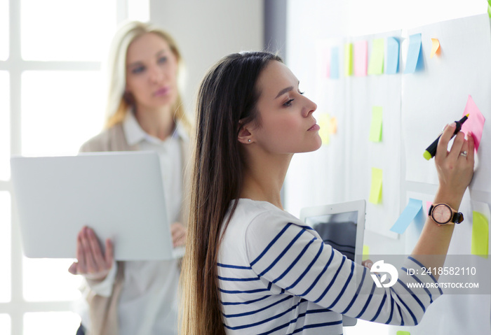 Closeup on business woman writing in flipchart in office