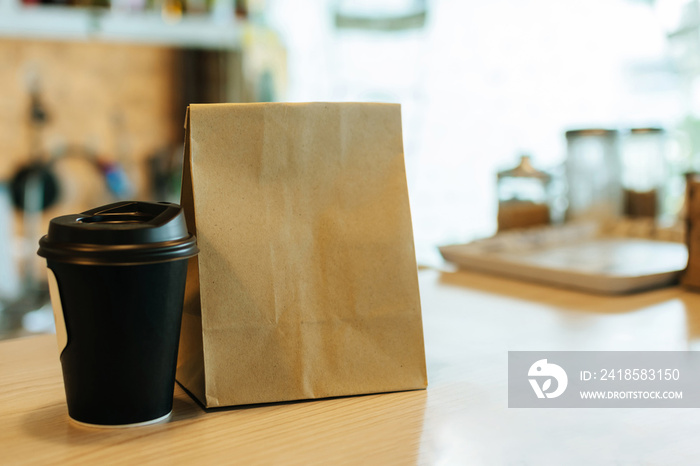 现代咖啡馆咖啡馆柜台上等待顾客的热黑咖啡杯和甜点纸袋