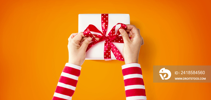 Person making a Christmas gift box - overhead view