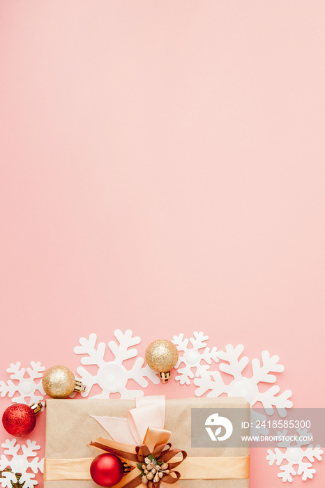 粉色背景上用缎带包裹的小礼物的特写镜头。圣诞背景。极简主义。
