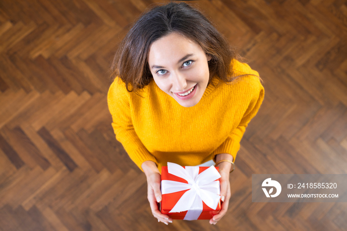 Happy young woman holding gift box