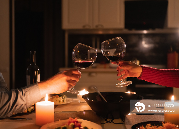 Couple clinking glasses of red wine celebrating valentines day, romantic date and dinner for two, a