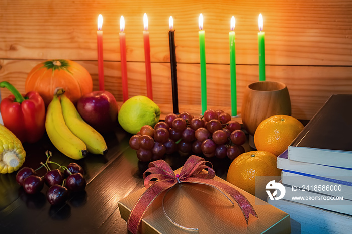 宽扎节节日概念，用红、黑、绿、礼盒、南瓜、玉米和七支蜡烛装饰