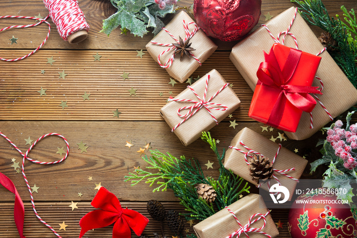 圣诞模型、用工艺纸包裹的礼盒、冷杉树枝、红色小饰品、木制松果