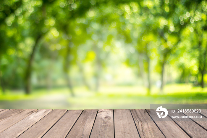 Wooden table with blurred of green natural tree in park background-Template mock up design for produ