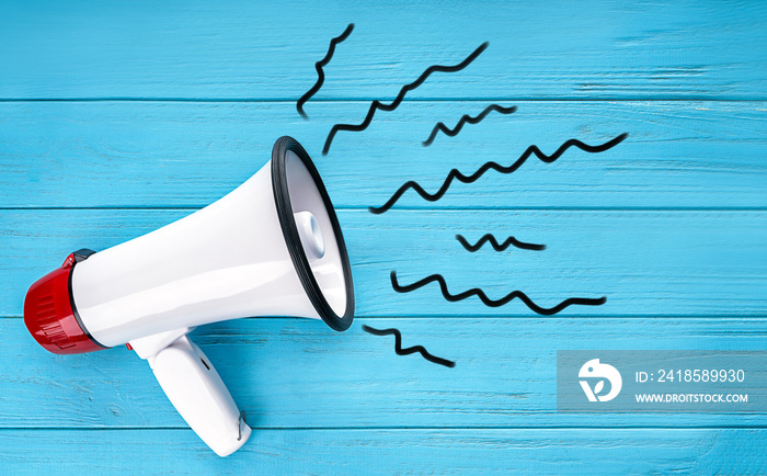 Megaphone on color wooden background