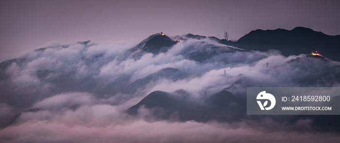 Mesmerizing view of mountain peaks covered by clouds on background of the cityscape