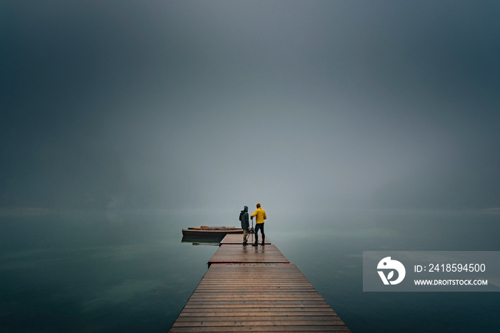 Wooden footbridge and person on it in  Lago di Braies (Braies lake, Pragser wildsee) South Tyrol, It