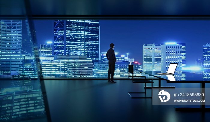 Rear view of successful businessman looking the city from his office , night scene .