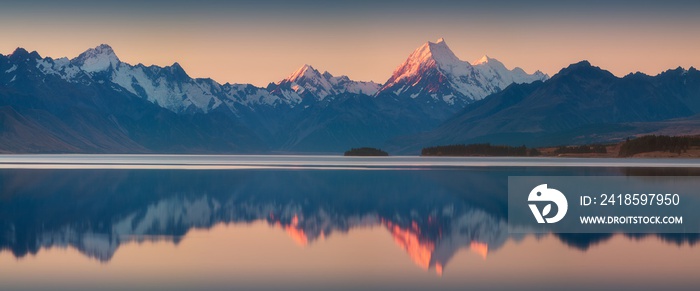 Snowy mountain range reflected in the still water of Lake Pukaki, Mount Cook, South Island, New Zeal