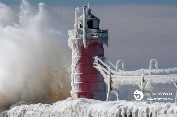 Winter landscape of the South Haven, Michigan Lighthouse with splashing wave, Lake Michigan, USA