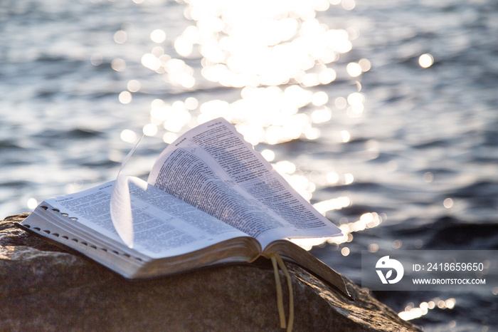 The bible on a stone against the sea