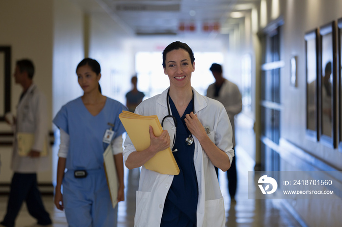 Portrait confident female doctor making rounds in hospital corridor