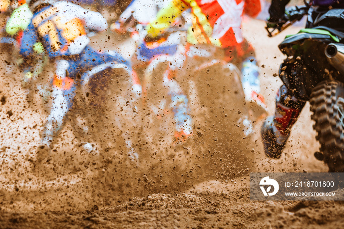 Details of flying debris during an acceleration with mountain bikes race in dirt track in sunshine d