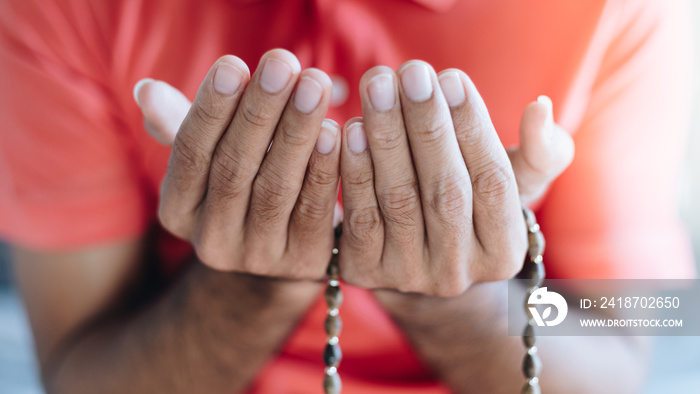 Close up Religious muslim man praying with rosary beads in hand