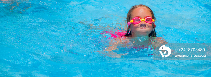 快乐可爱的小女孩学会游泳，在游泳池里放松。热门国家的假期概念