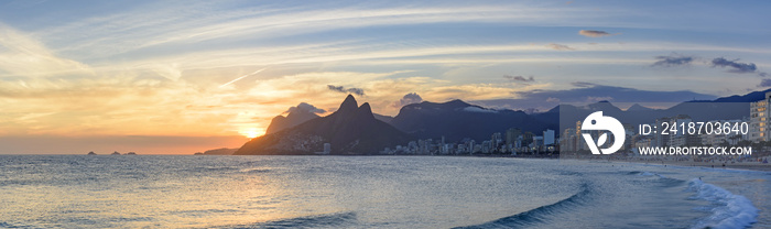 Summer sunset at Ipanema beach in Rio de Janeiro with Leblon beach, Two Brothers hill and Gavea ston