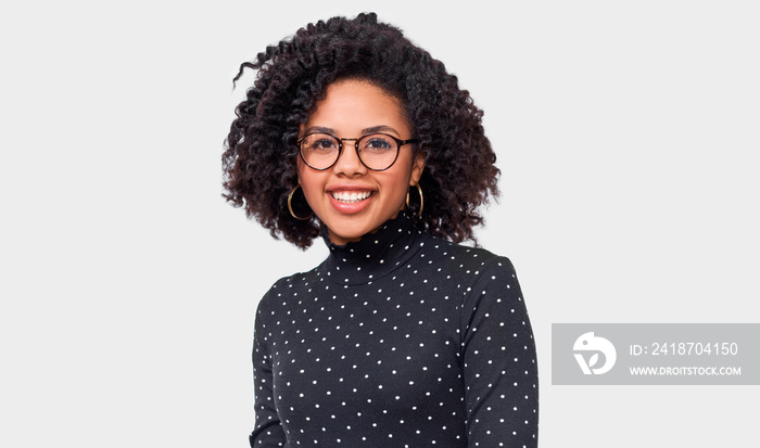 Studio portrait of African American young woman dressed in black with white dots long sleeve shirt, 