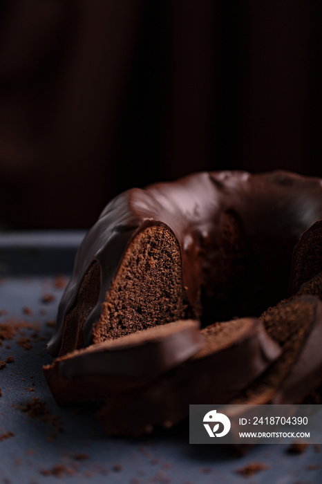 Dark chocolate cake covered with icing covered on a dark background. Selective focus.