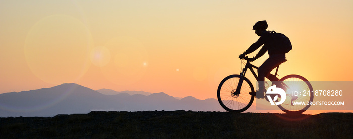 silhouette of a person riding a bike