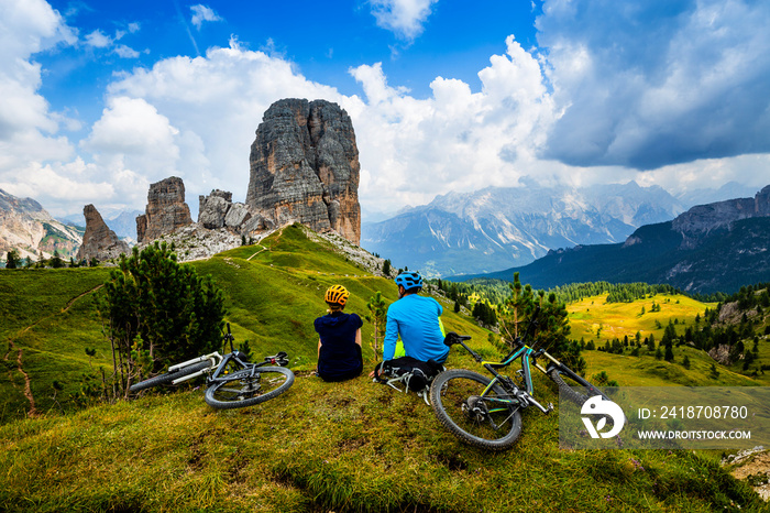 Mountain cycling couple with bikes on track, Cortina dAmpezzo, Dolomites, Italy