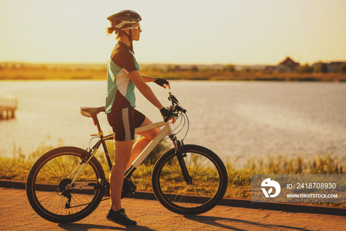 Woman on bike at the lake water background in the park