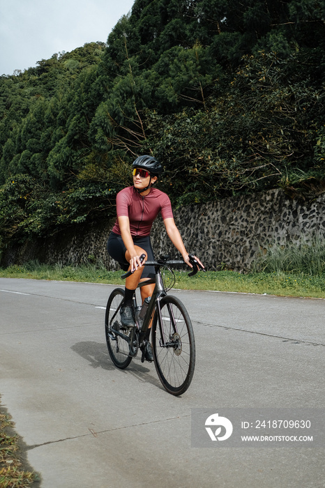 A young female cyclist riding her gravel bike in the mountains.