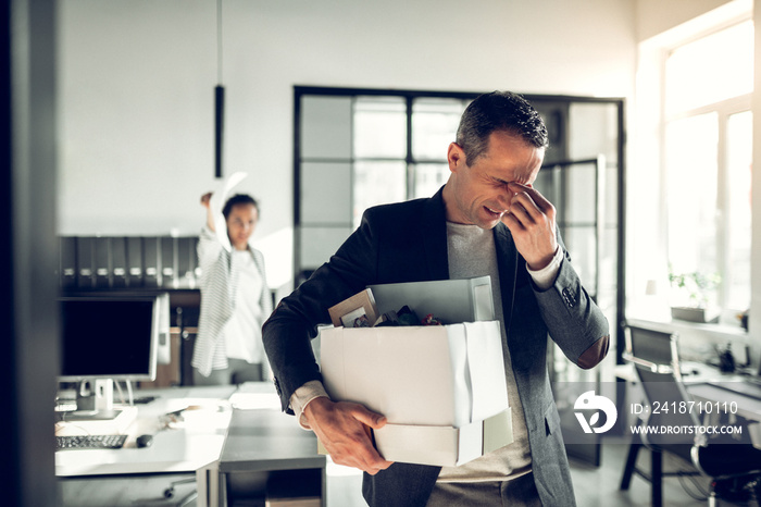 Man having headache while listening to his crazy female boss