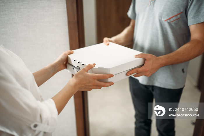 Pizza delivery man gives box to female client