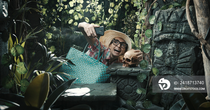 Funny tourist taking a selfie in the jungle with a skull