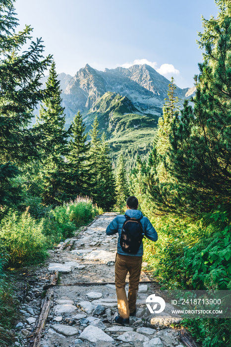 Man walking on hiking trail in Tatra mountains in Poland