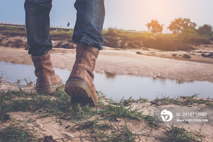 Man in hiking boots standing on edge of a cliff