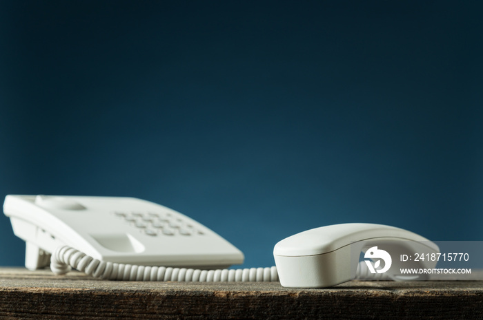 White landline telephone with handset off the hook