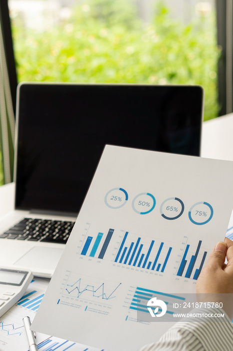 A financial businessman and calculator calculates and analyzes graphs on real estate investment cost