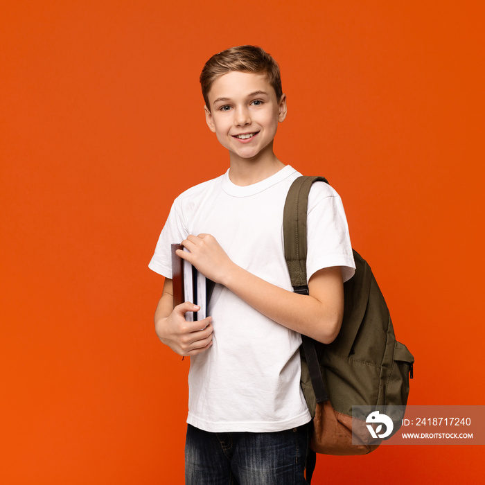 Teen boy ready for getting education, smiling with books and backpack