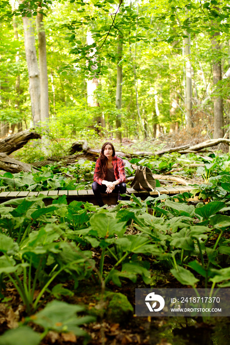 Young woman sitting on boardwalk