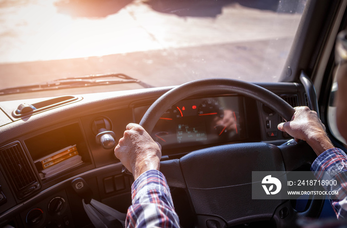 Truck driver keeps driving with one hands and change gears,The man Behind Semi Truck Steering Wheel,