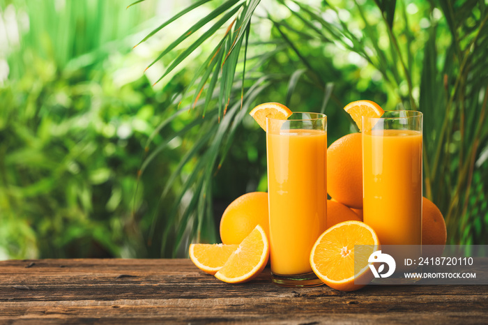 Glasses of fresh orange juice on table outdoors