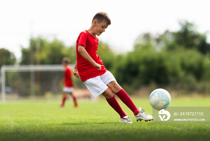 Boy kicking soccer ball