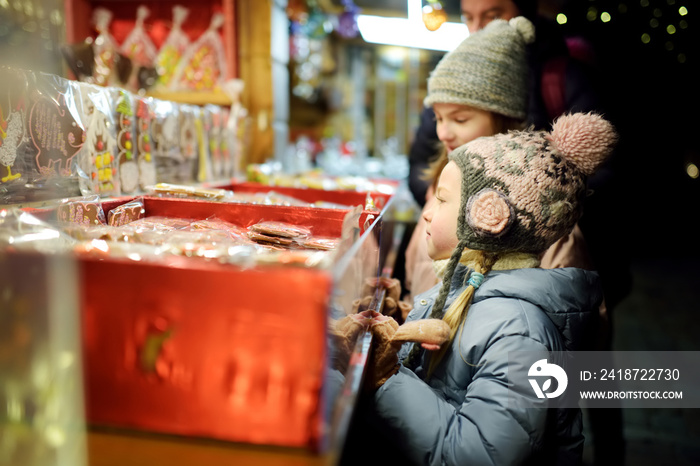 可爱的小姐妹在拉脱维亚里加的传统圣诞市场上挑选糖果。孩子们在买糖果