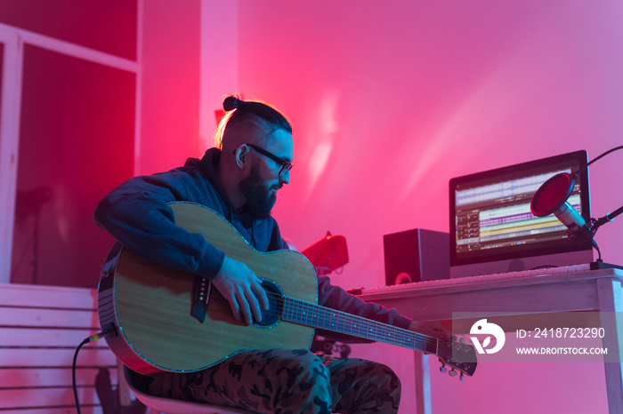 Create music and a recording studio concept - Bearded man guitarist recording electric guitar track 