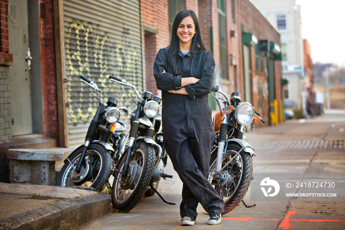 Female mechanic next to motorcycles