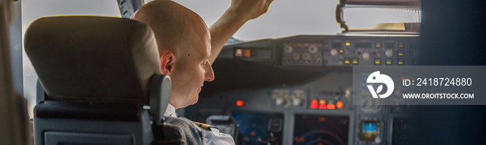 Focused professional pilot sitting in an airplane cabin, ready for takeoff. Aircraft, aircrew, occup