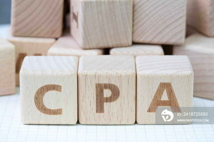 CPA, Certified Public Accountant or Cost per Action concept, cube wooden block building word CPA, ce