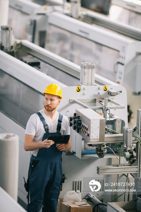 Man with helmet working in factory.