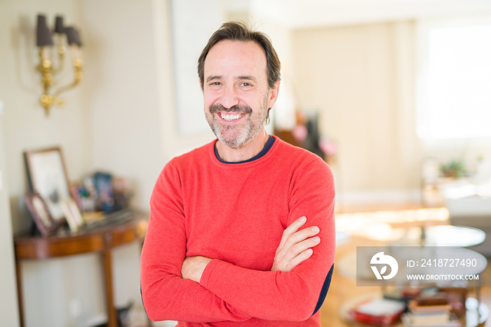 Handsome middle age man smiling looking at the camera at home