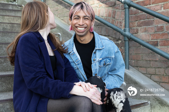 Lgbtqia friends posing on stairs outside.