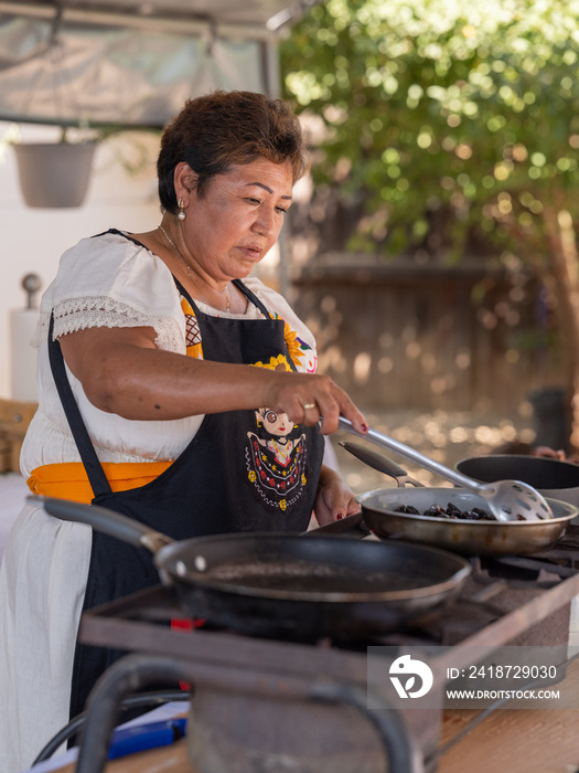 在户外厨房里准备食物的土著妇女