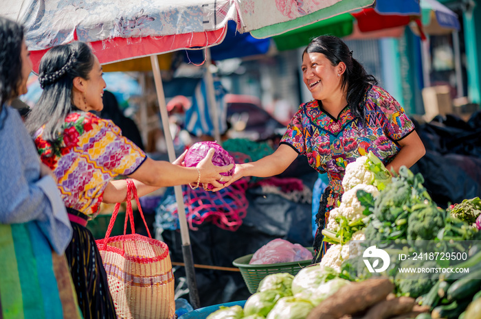 Vendedora feliz de un mercado de Quetzaltenango atiende a su cliente.