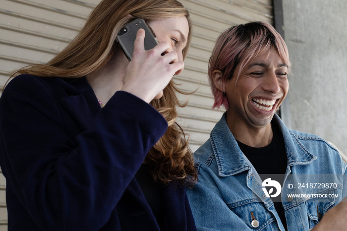 Lgbtqia friends laughing on their phone.